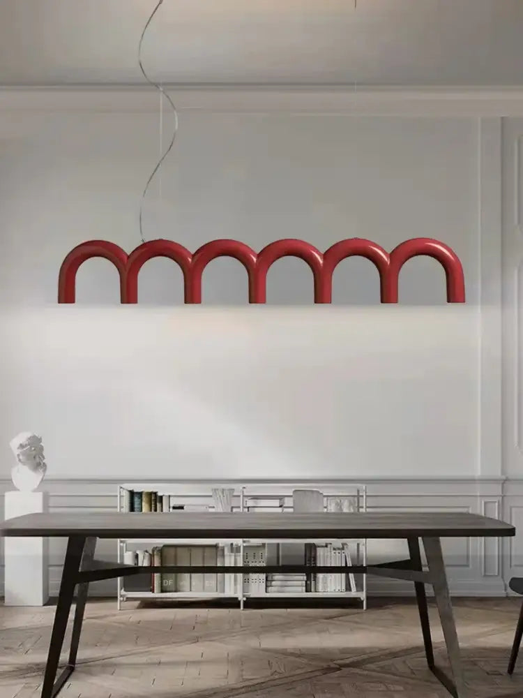 A modern red DecorBites™ arch chandelier with curved arch-shaped segments suspended from the ceiling