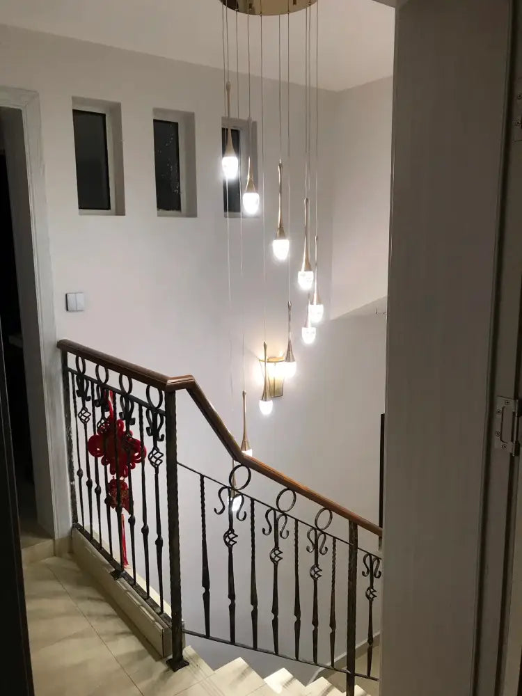 DecorBites™ modern gold-toned led crystal chandelier with multiple hanging bulbs above staircase for home decor