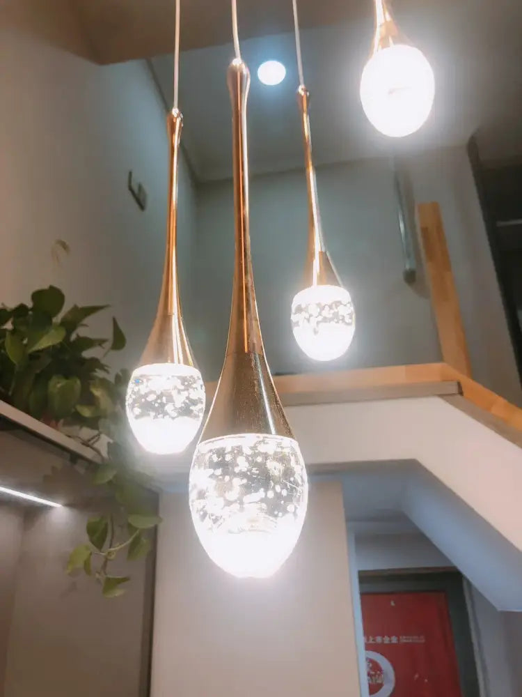 Three elegant gold-toned led crystal chandelier pendant lights with frosted glass globes and sparkling patterns for home decor