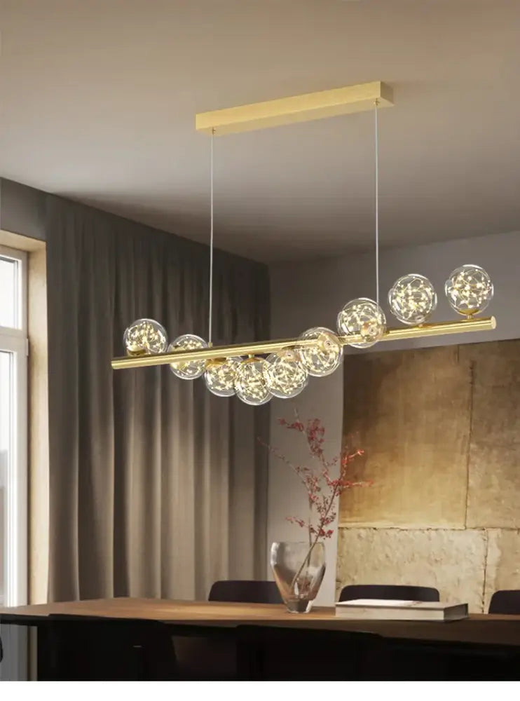 Gold-toned modern led glass chandelier with spherical glass globes and horizontal bar design for dining room lighting