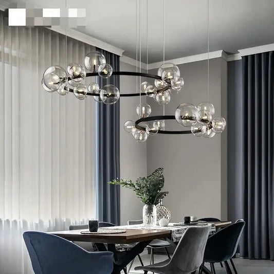 Modern black metal chandelier with adjustable cord featuring clear glass bubble bulbs in concentric circular patterns