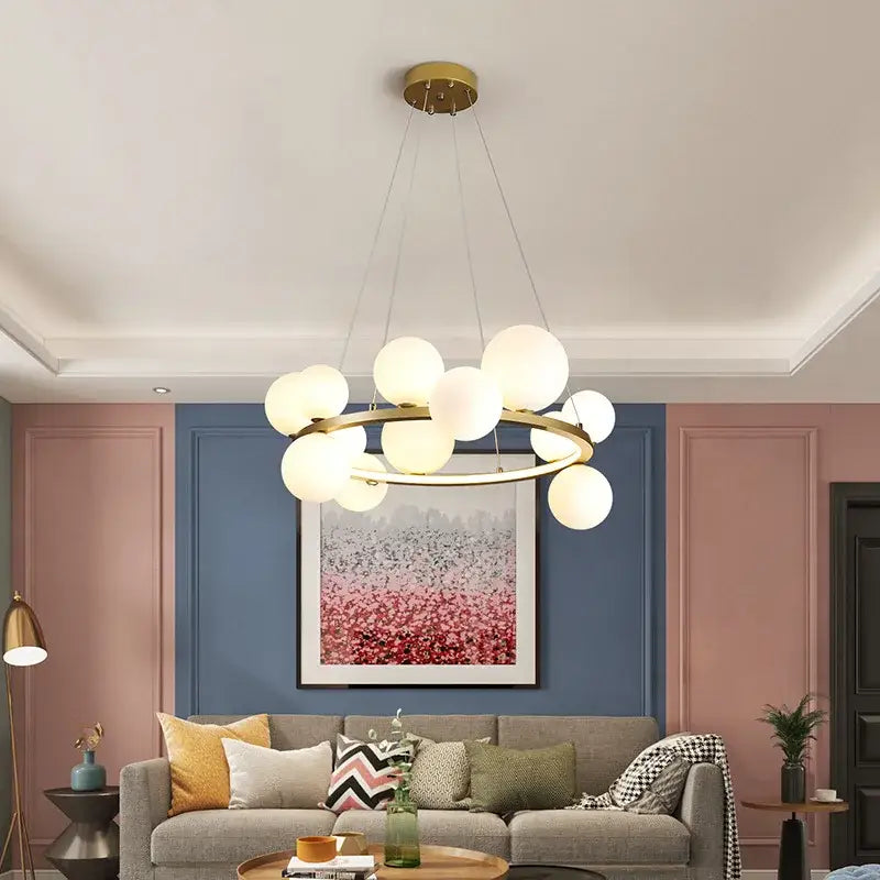 DecorBites™ modern gold-toned chandelier with frosted glass globe lights and adjustable cord in circular design