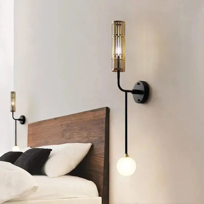 Decorbites modern wall sconce with black metal arm and gold accents featuring a cylindrical shade and frosted bulb