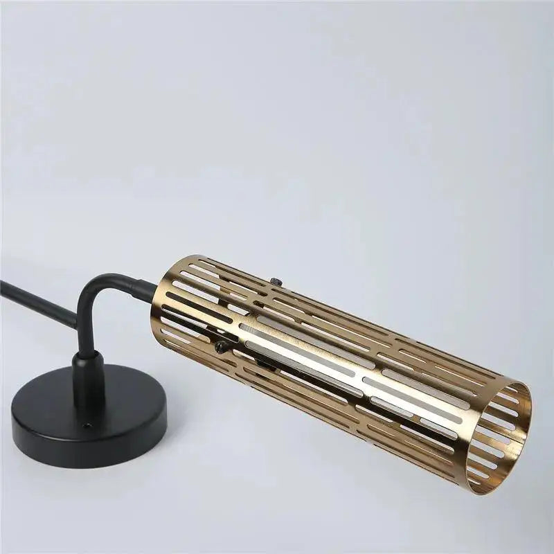 Decorbites™ modern wall sconce with gold accents featuring a gold-toned perforated cylindrical lamp and black base