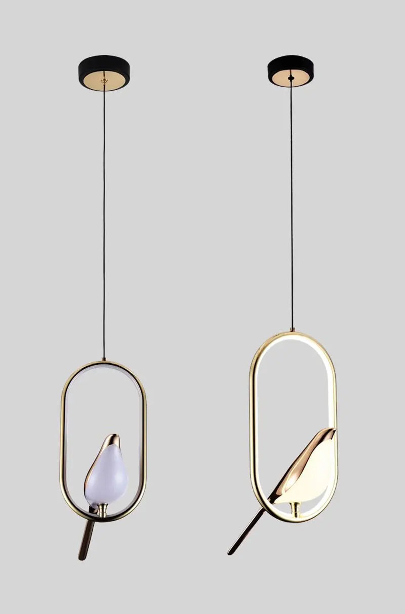 Two gold-toned decorbites™ modern magpie bird led pendant lights with oval frames and illuminated bird-shaped bulbs