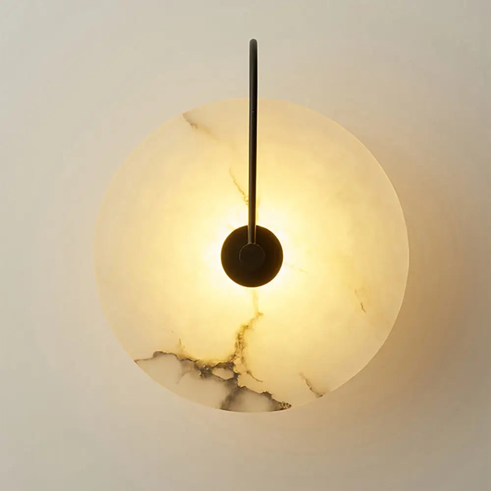 Warm-toned circular onyx marble wall lamp with sleek black metal arm from decorbites modern marble wall collection