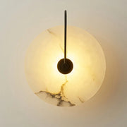 Warm-toned circular onyx marble wall lamp with sleek black metal arm from decorbites modern marble wall collection