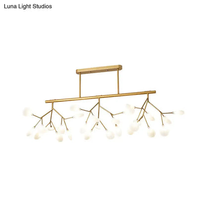 Gold-toned modern metal linear island chandelier with branching arms and frosted glass globe bulbs by DecorBites