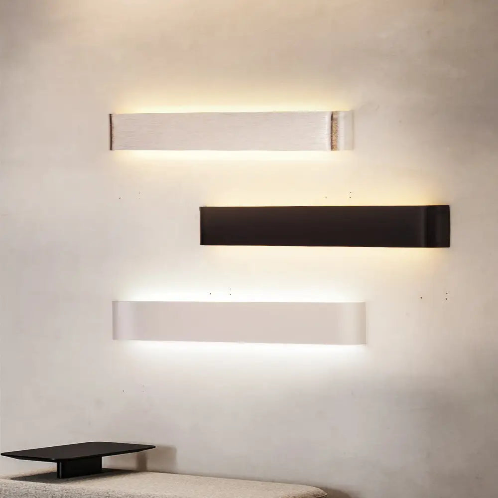 Decorbites™ modern metal wall sconces in sleek white and matte black finishes emitting warm ambient glow