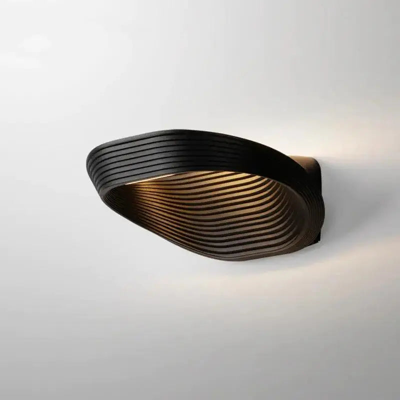DecorBites™ modern minimalistic wall sconce in black with sleek curved design and concentric ridged texture