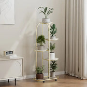 Gold-finished metal plant stand with five tiered shelves and caster wheels for modern interior decor flower rack