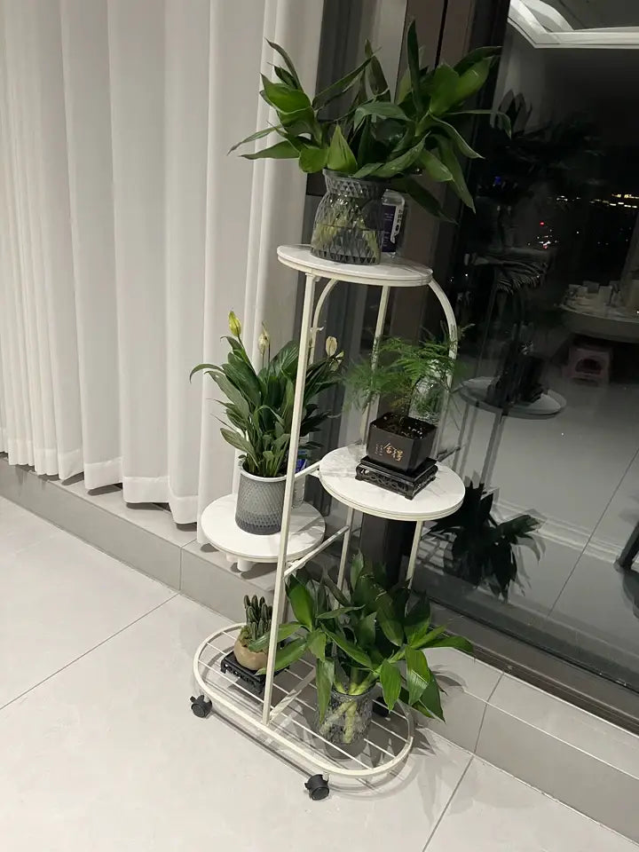 White metal DecorBites™ modern multi-storey plant stand with three tiers and black caster wheels for interior decor