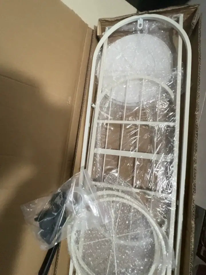 White metal garden arbor with curved top lattice design as DecorBites modern multi-storey plant stand for interior decor