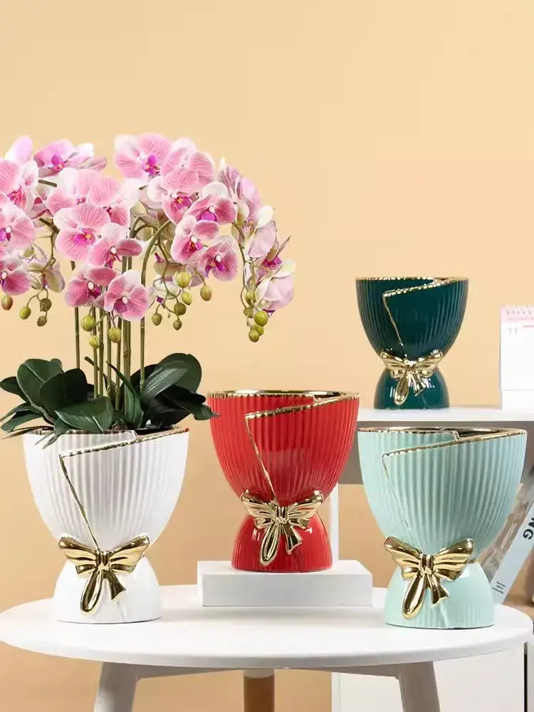 A set of three modern nordic ceramic vases in white red and mint green with gold ribbon bows for home decor