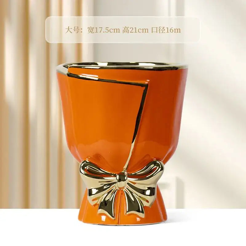 Vibrant orange modern nordic ceramic vase with glossy finish gold-trimmed crack design and metallic bow for home decor