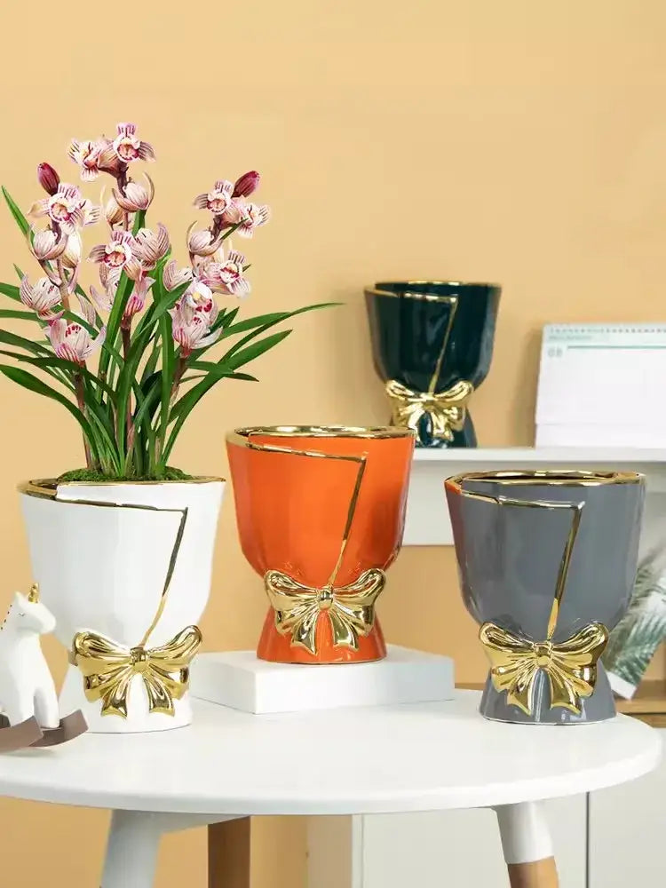 White ceramic vase with gold geometric accents and bow design for modern nordic home decor by DecorBites™