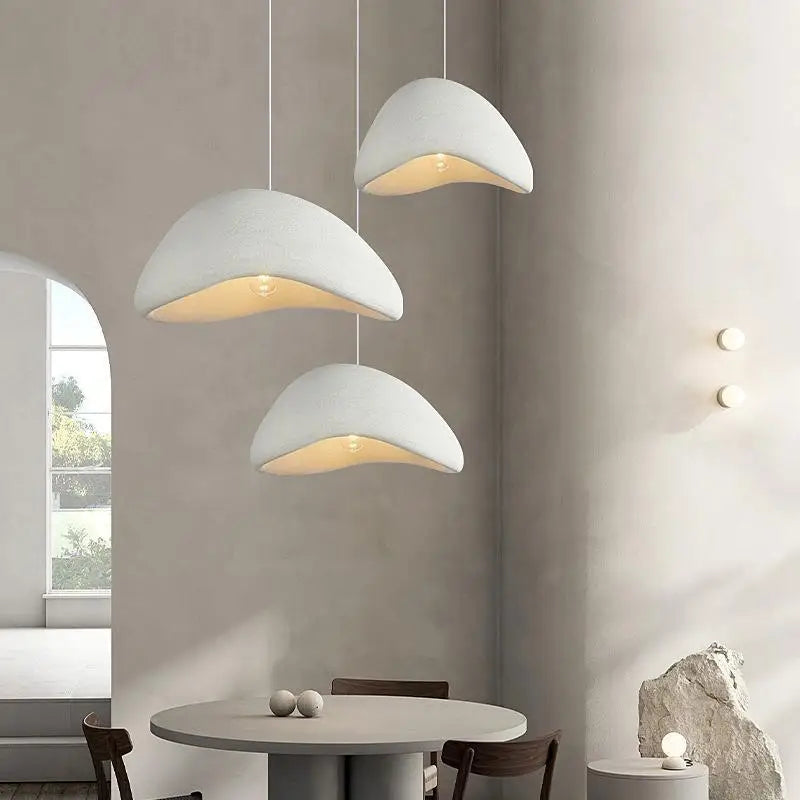 Three white shell-shaped pendant lights with warm light turn in the modern nordic chandelier for home and dining