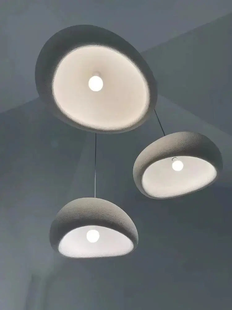 Three modern matte concrete pendant lights with soft white interiors for warm light turn modern nordic chandelier