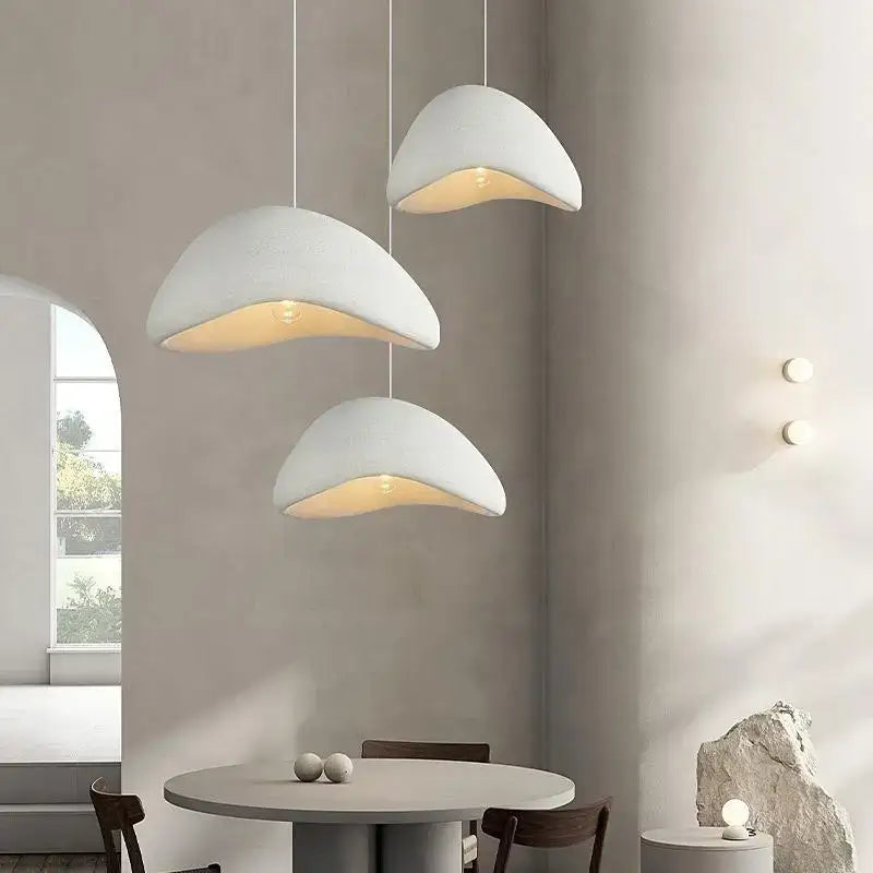Three white shell-shaped pendant lights with warm light turn in the modern nordic chandelier for home and dining