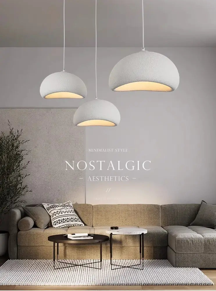Three white dome-shaped pendant lights with textured surface emitting warm light in decorbites™ modern nordic chandelier