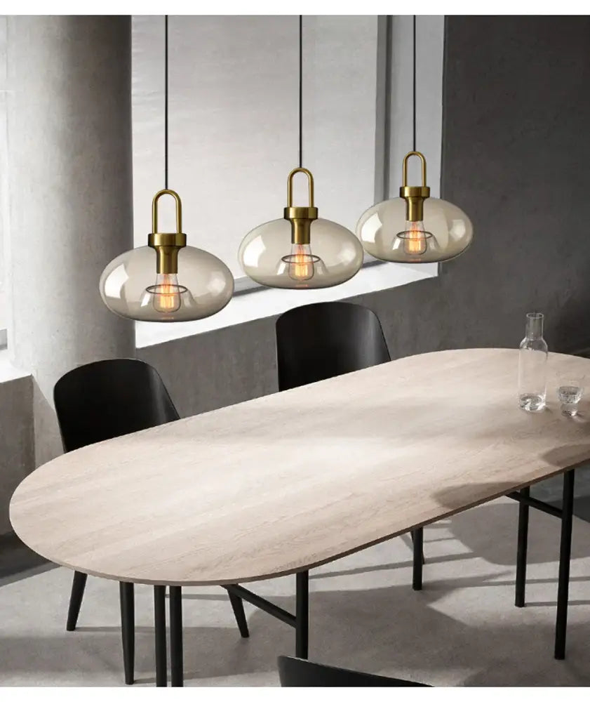 Three decorbites™ modern nordic glass pendant lights with brass fixtures and smoke-gray globes for kitchen or restaurant use