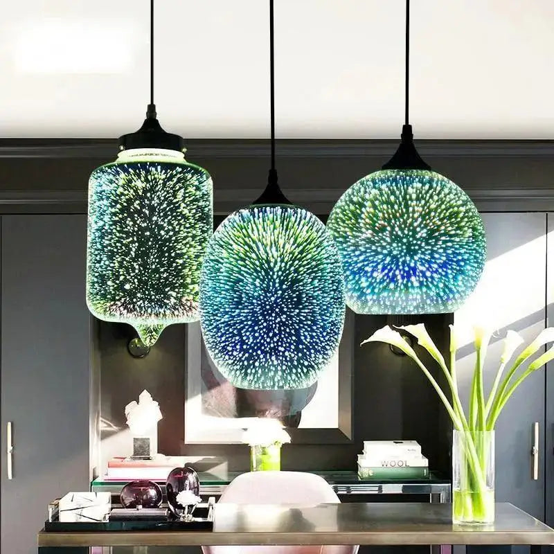 Three modern nordic glass pendant lights with blue and green 3d starburst effect and black metal fixtures by DecorBites