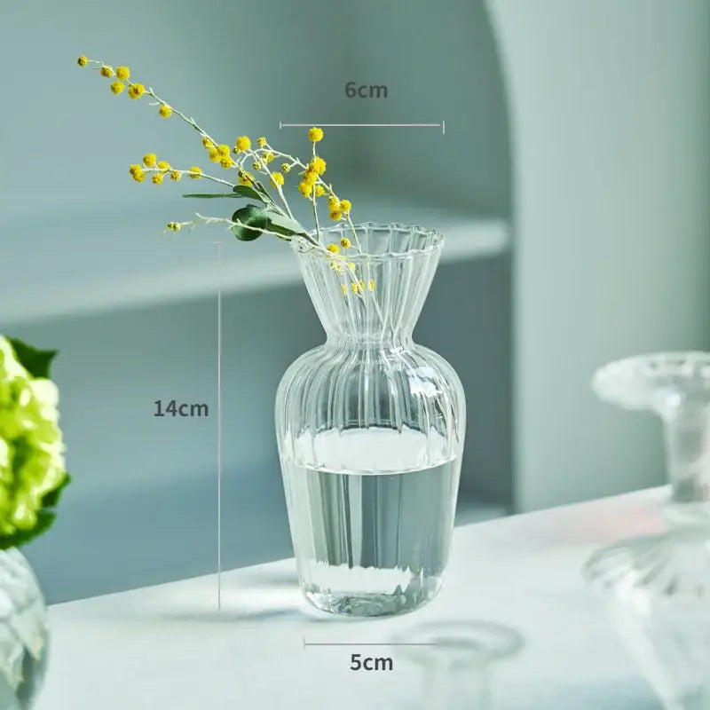 DecorBites™ modern Nordic clear glass vase with vertical ridges and fluted rim holding yellow flowers in water