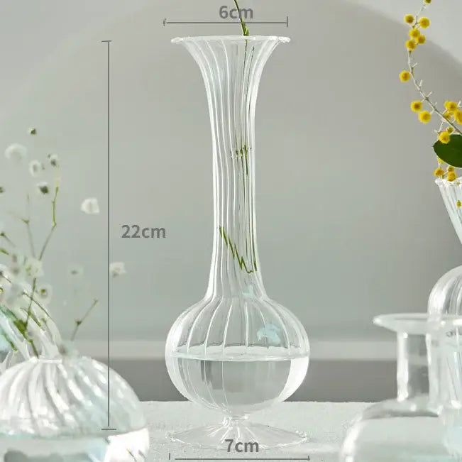 DecorBites modern Nordic clear glass vase with vertical ridges and flared top holding delicate green stems for decorate root