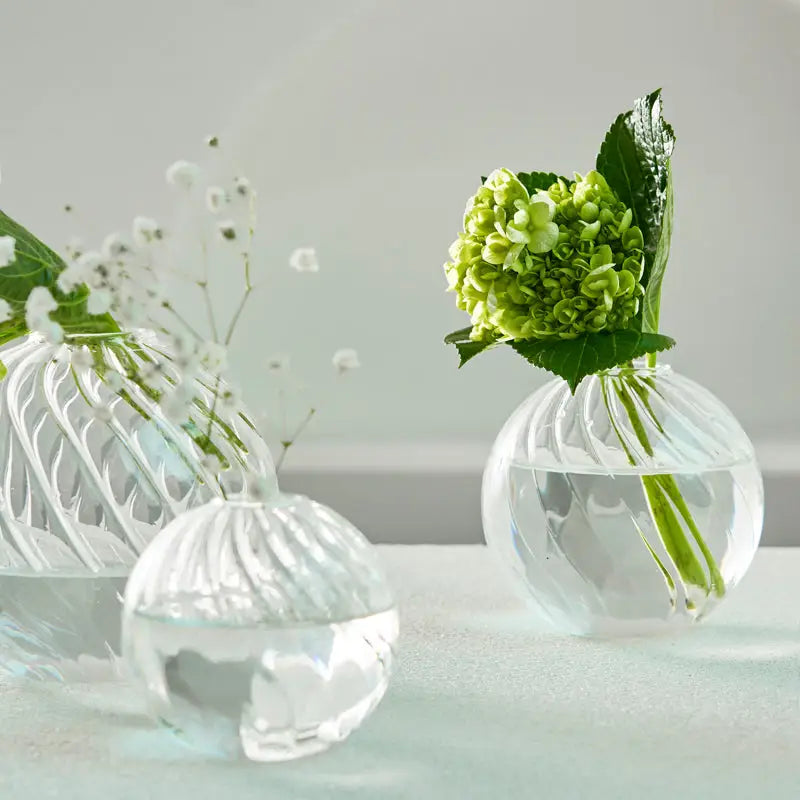 Clear glass spherical DecorBites™ modern nordic vases with ribbed patterns holding green hydrangeas and white baby’s breath