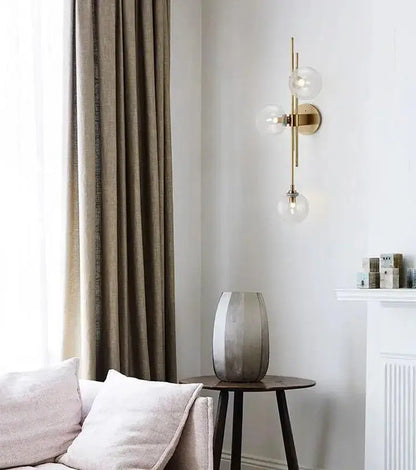 Decorbites modern nordic gold-toned wall sconce with three clear glass globe bulbs for elegant lighting decor
