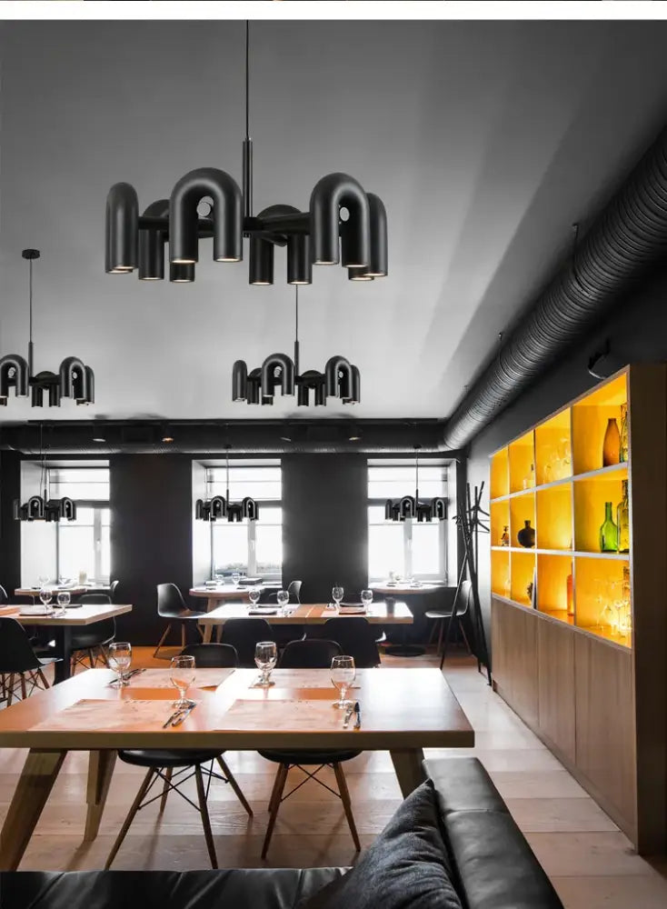 Black industrial-style led ceiling chandelier with geometric curved pipe arms for modern home decor by DecorBites
