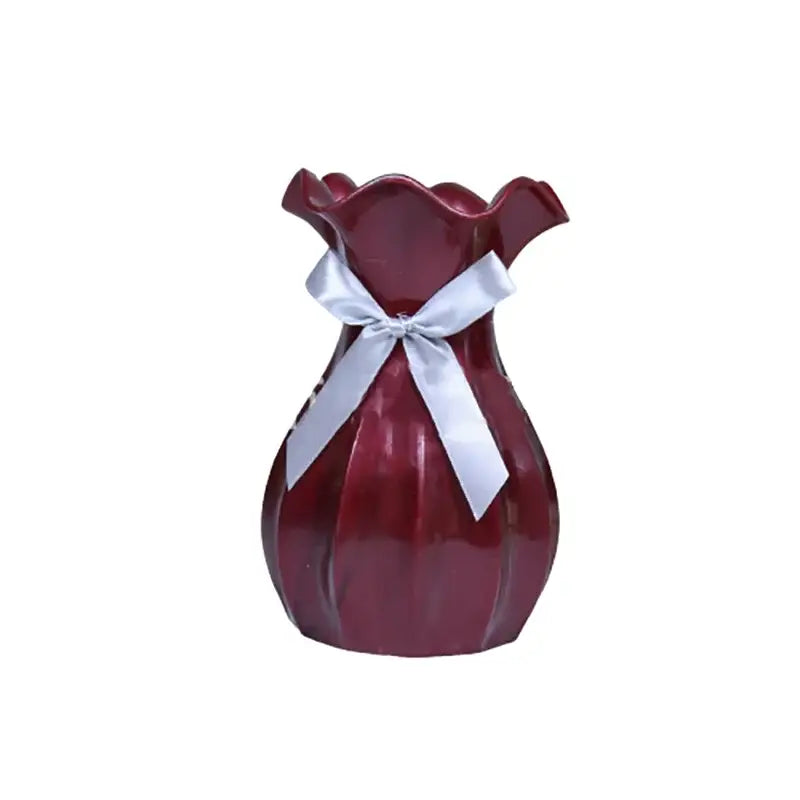 A glossy deep red ceramic vase home with a fluted rim and silver satin ribbon for modern nordic flower vase home decor