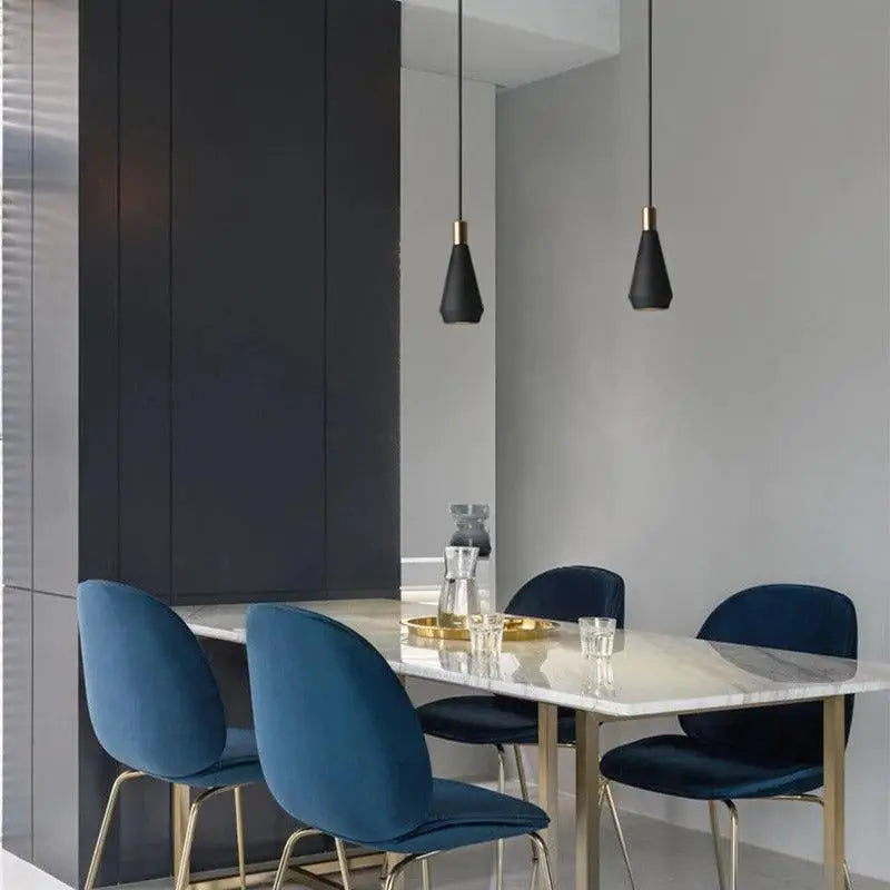 Deep blue velvet dining chairs with gold tone metal legs complement modern nordic pendant light for elegant hanging lights