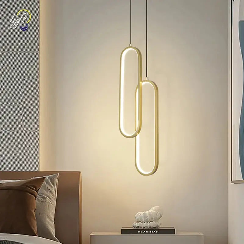 Modern gold-toned DecorBites™ nordic pendant light with sleek elongated oval design and warm ambient glow for home decoration