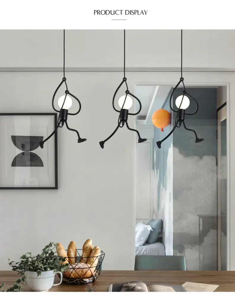 Three black metal pendant lights shaped like playful stick figures with glowing bulbs for modern nordic pendant light decor