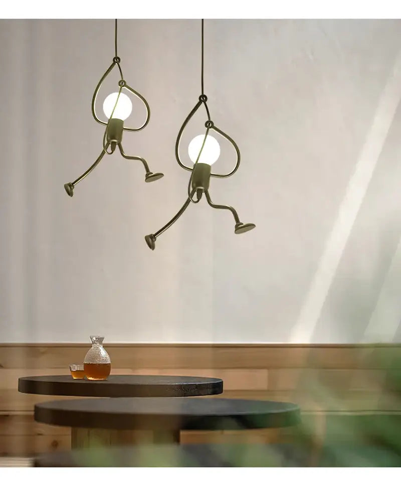 Two whimsical bronze-colored metal pendant lights shaped like running stick figures nordic pendant light for home decoration