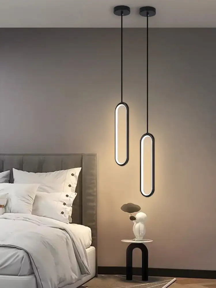 Two sleek black-framed DecorBites™ modern nordic pendant lights with warm led illumination hang from the ceiling