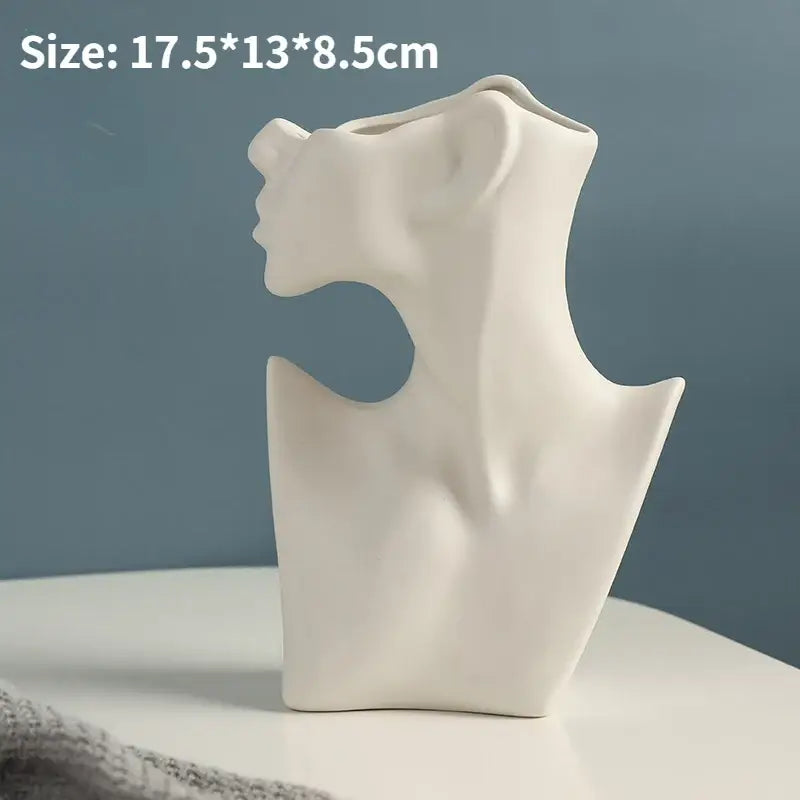 White ceramic vase shaped like a stylized female bust with sculpted contours and nordic style ceramic design