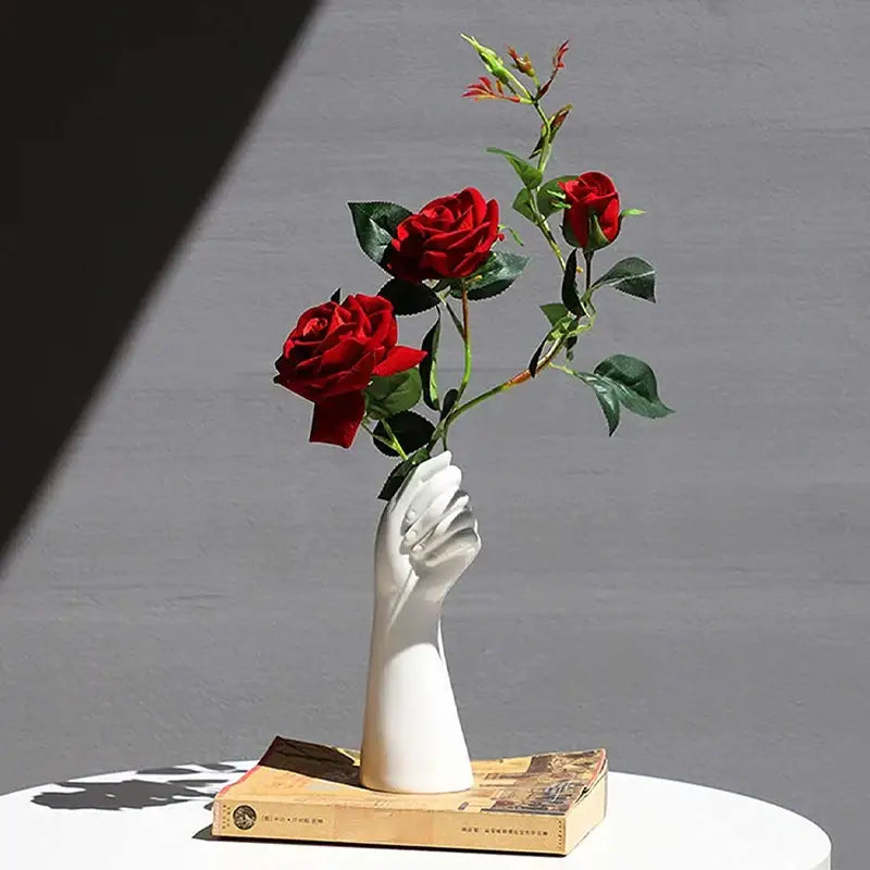 White ceramic hand vase shaped like a hand holding roses in modern nordic style by DecorBites™