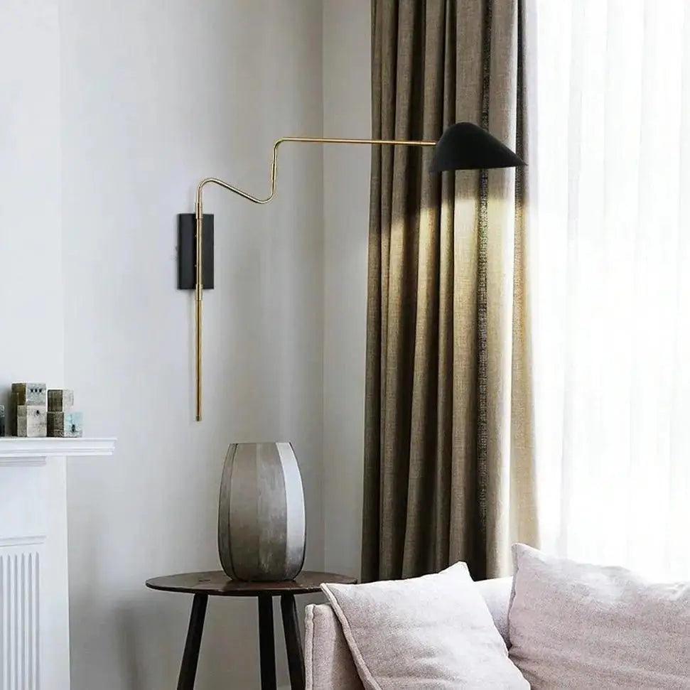 A sleek black conical decorbites™ anneke wall sconce with a curved brass arm mounted on the wall