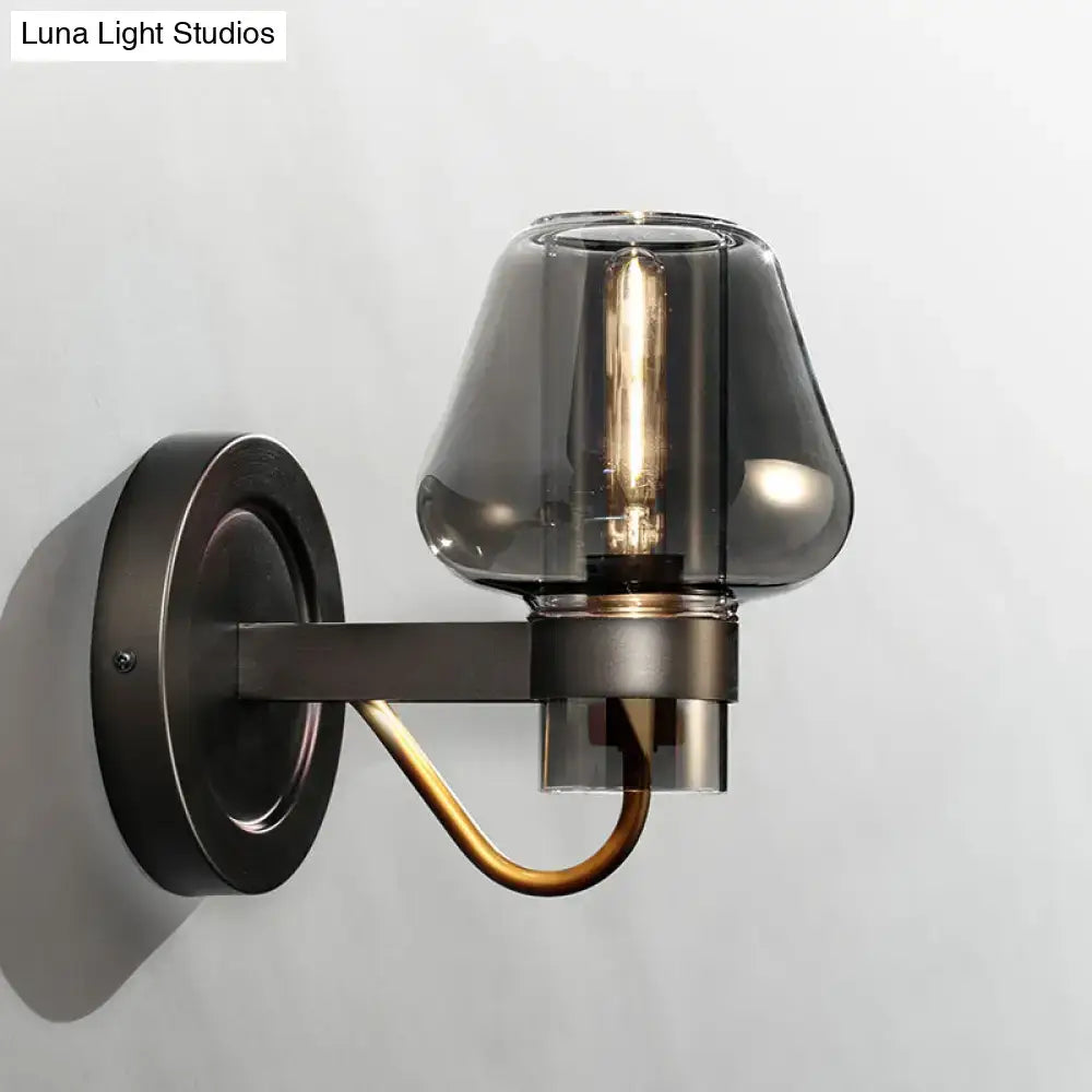 Dark bronze wall sconce with modern smoked glass mushroom shade and brass accent lighting fixture for bedroom use