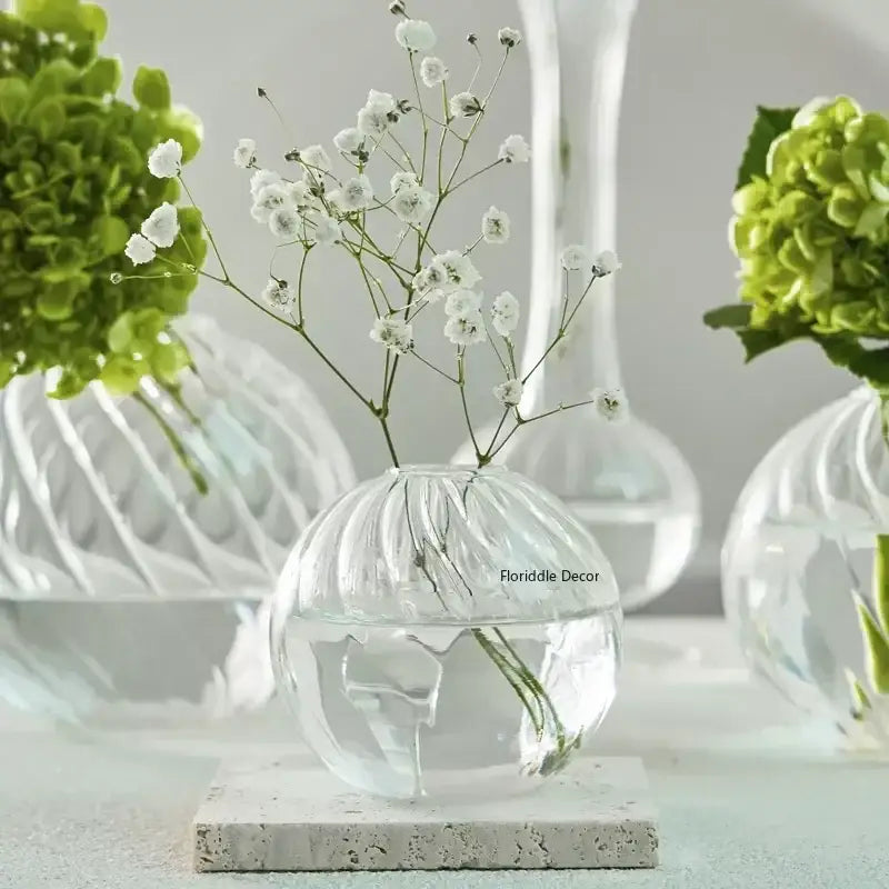 Clear glass spherical vase with ribbed texture holding white babys breath flowers from decorbites modern transparent glass vases set