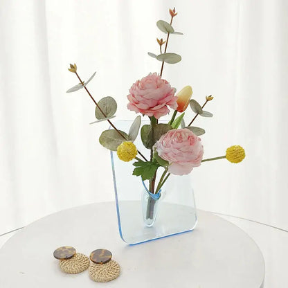 DecorBites™ modern transparent square vase with blue tint holds pink peonies yellow tulips and green eucalyptus leaves