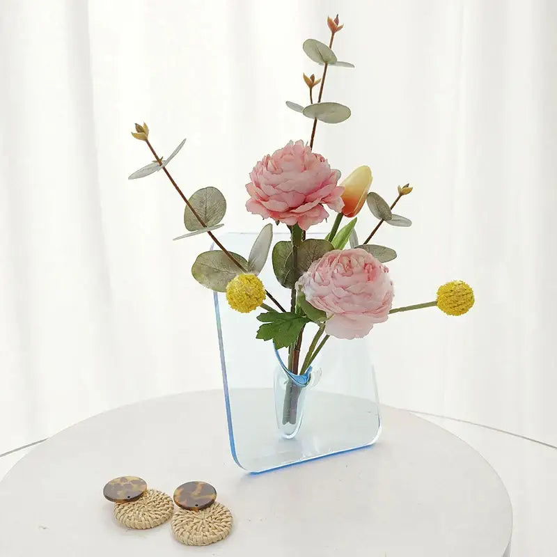 DecorBites™ modern transparent square vase with blue tint holds pink peonies yellow tulips and green eucalyptus leaves