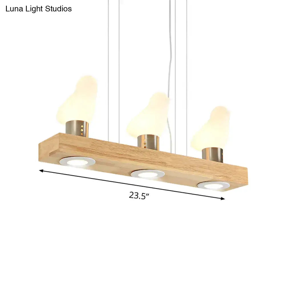 DecorBites™ modern wood island light with three warm-toned glass shades and brass accents for dining room use
