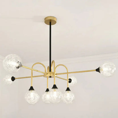 Gold-toned DecorBites Modo 6-head chandelier with clear textured glass globes and black accents for dining room lighting