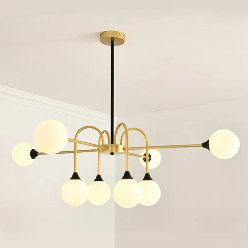 DecorBites™ Modo 8-head dining room chandelier in brass and black with frosted glass globe bulbs and gold finish