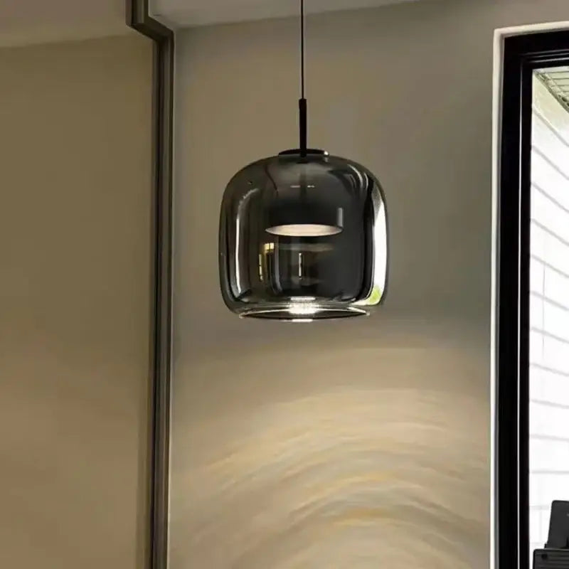 A sleek dark gray glass pendant light with black metal fixture in the modern nordic pendant style by DecorBites™