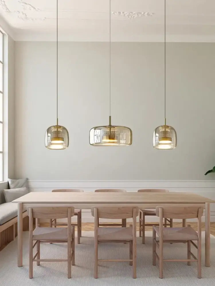 DecorBites™ Moroccan amber modern nordic pendant light features clear glass and brass accents above wooden table