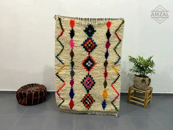 Beige moroccan handmade azilal rug with colorful geometric patterns on textured woolen surface by decorbites™ 1.5m x 1m